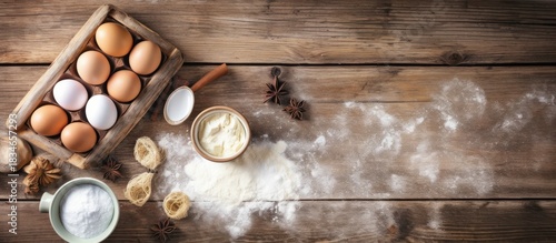 Baking ingredients on wooden table, eggs, flour, and other elements.