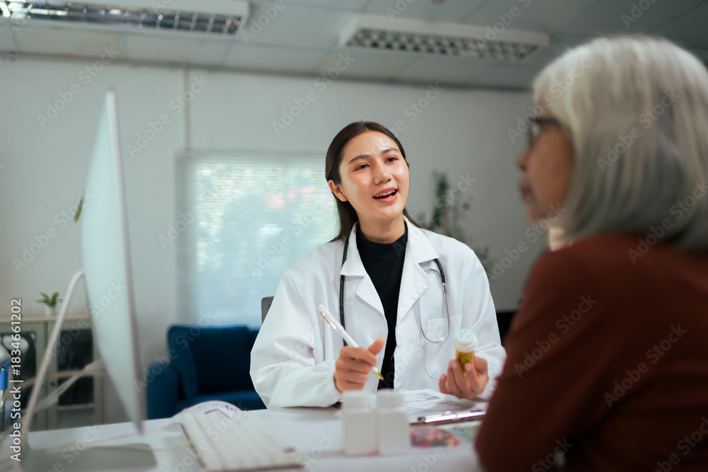 Fototapeta premium Asian doctor consulting elderly patient about medication