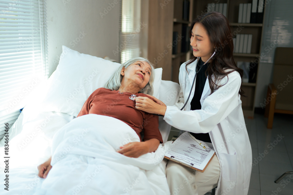 Fototapeta premium Female doctor checking senior Asian patient in hospital bed
