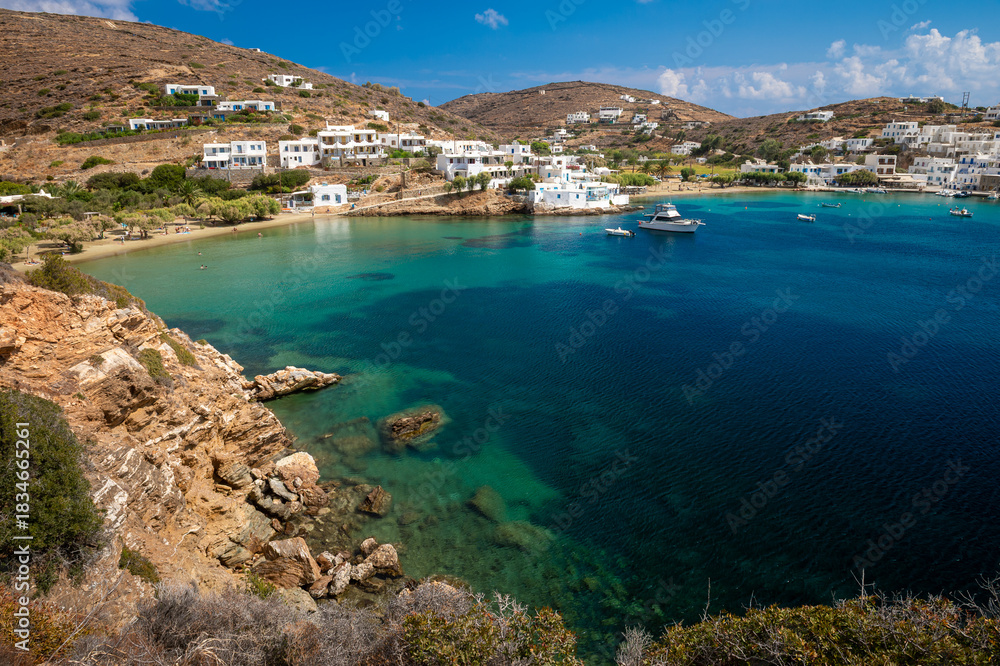 Obraz premium View from cliff trail across the calm turquoise waters of Vilcho beach to Faros on the greek island of Sifnos