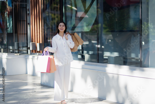 Smiling woman while shopping, enjoying a colorful shopping experience, holding her purchases with joy, representing style, positivity, wealth, modern urban atmosphere and energy.