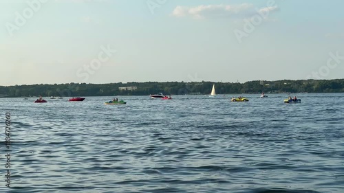 Colorful kayaks and boats glide across a serene lake, capturing the essence of summer leisure, with a gradual zoom in on the vibrant scene