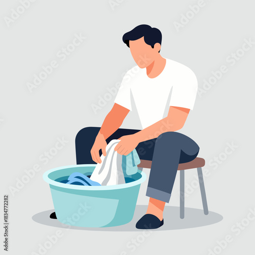 A man is engaged in hand washing clothes in a basin, representing a common domestic laundry activity.
