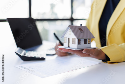 Mortgage Real Estate Broker presenting and advised to model home and building project detail in the office, sign purchase sales contract, agreements concerned mortgage loan offer and insurance.
