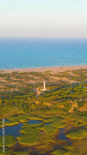 Vertical video. Gelemis, Turkey. Aerial morning view of Patara Beach, Mediterranean Sea, restored Roman lighthouse and ancient harbour marshes from Tepecik Hill. Aerial View. Rich colors