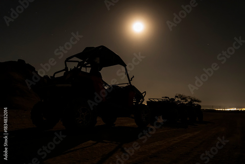 Buggies and ATVs in Egyptian desert at night. Night riding and entertainment for tourists