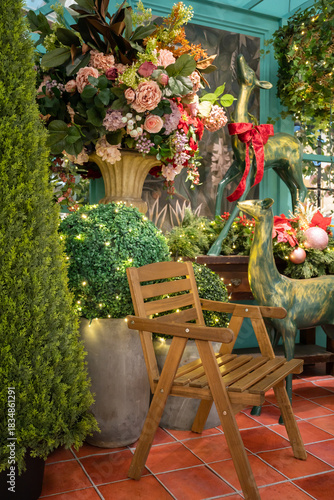 A cozy outdoor garden scene featuring a wooden chair, vibrant flower bouquets, lush greenery, and decorative statues, perfect for garden decor, events, and nature inspired home design.