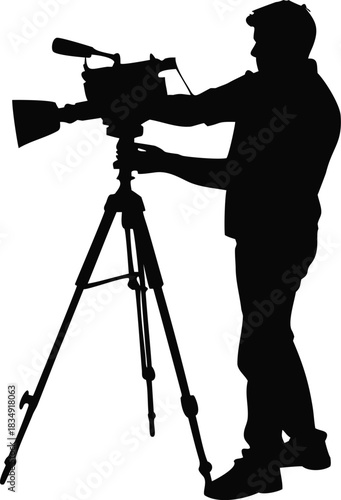 A silhouette of a videographer operating a professional camera on a tripod stand