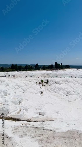 Pamukkale, the cotton castle and cotton hill, white travertine natural hot spring and ancient Roman Greek bath house at Hierapolis ruins site, Turkiye