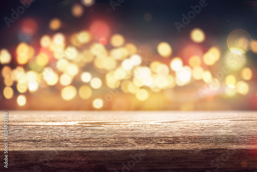 empty wooden table with Christmas gold and multicolored unfocused lights in the background. Ideal for displaying products.