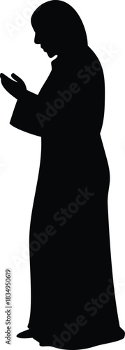 A silhouette of a woman in traditional islamic clothing praying with devotion high-quality