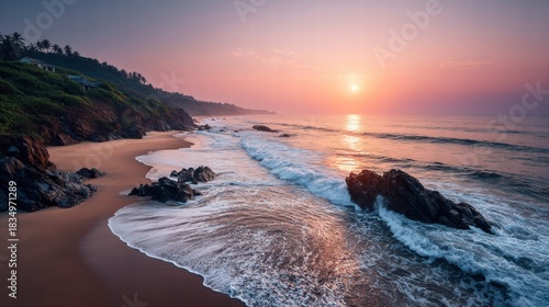 Sunset over a scenic beach with waves crashing on the shore.