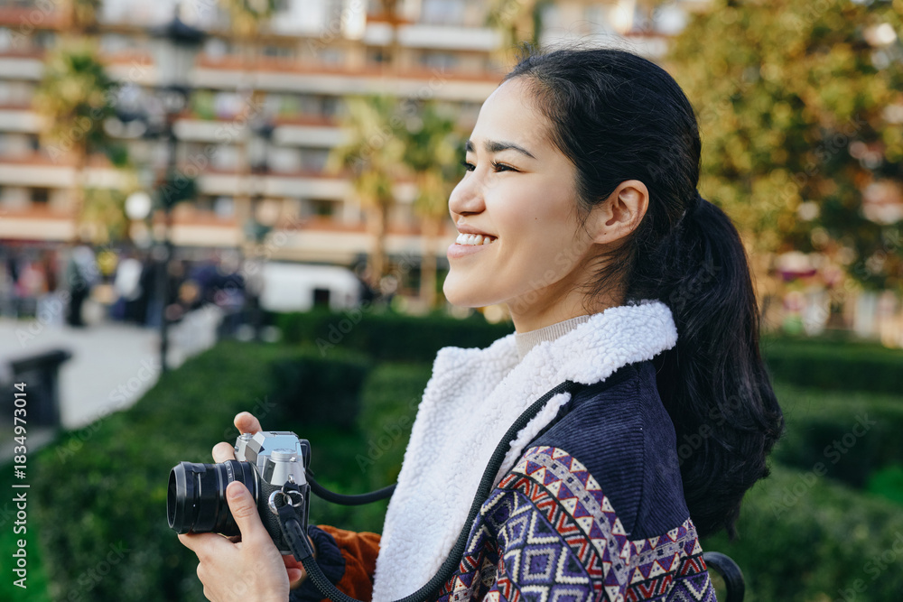 Obraz premium Camera, photography, woman, outdoor, park, candid, smiling, lens, photographer, equipment in a bright park setting, capturing a joyful moment with natural light and greenery