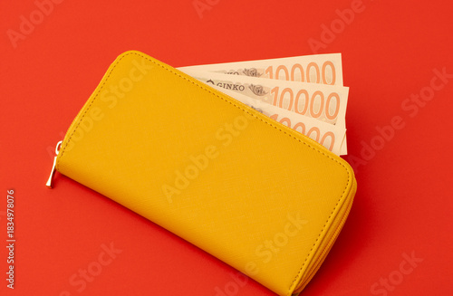 Yellow wallet and Japanese banknotes. Household finances, savings, good fortune, financial luck, deposits, property, expenses, budgets, etc. 黄色の財布と日本紙幣（お金）。家計、預金、幸運、金運、貯金、財産、出費、予算など