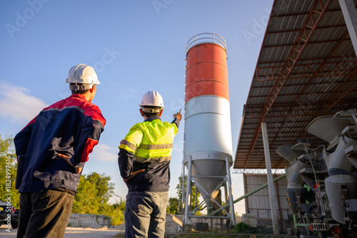 Wallpaper Mural Two engineers evaluating the concrete plant structure, checking silo conditions and workflow efficiency at an industrial concrete batching facility. Torontodigital.ca