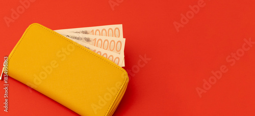 Yellow wallet and Japanese banknotes. Household finances, savings, good fortune, financial luck, deposits, property, expenses, budgets, etc. 黄色の財布と日本紙幣（お金）。家計、預金、幸運、金運、貯金、財産、出費、予算など