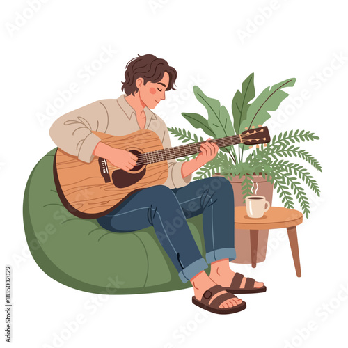 Young man relaxes playing acoustic guitar in comfy beanbag chair
