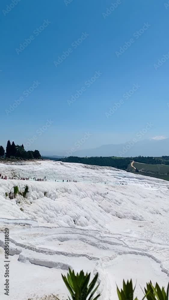 Pamukkale, the cotton castle and cotton hill, white travertine natural hot spring and ancient Roman Greek bath house at Hierapolis ruins site, Turkiye 