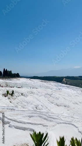 Pamukkale, the cotton castle and cotton hill, white travertine natural hot spring and ancient Roman Greek bath house at Hierapolis ruins site, Turkiye