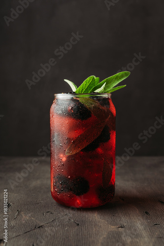 Blackberry sage cocktail with fresh branches on rustic wood. Selective focus.
