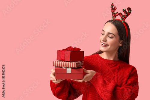 Christmas shopping and holiday gift giving, happy young woman holding a stack...
