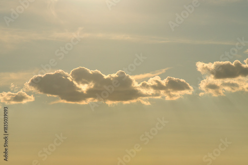 Sunbeams break dramatically through dense clouds in the orange sky.