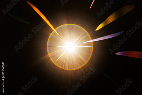 Lens Flare. Light over black background. Easy to add overlay or screen filter over photos. Abstract sun burst with digital lens flare background. Gleams rounded and hexagonal shapes, rainbow halo.