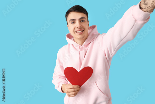 Young man with heart taking...