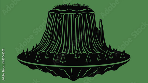 Majestic monolithic rock formation with a crown of green grass and surrounding trees.