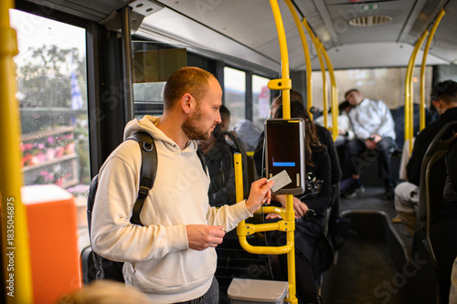 Foto Man riding a bus and validating his ticket on public transport, commuting, urban daily routine, city lifestyle and transportation concept