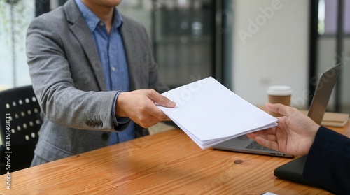 Corporate hands exchanging essential documents during a business meeting transaction process on desk