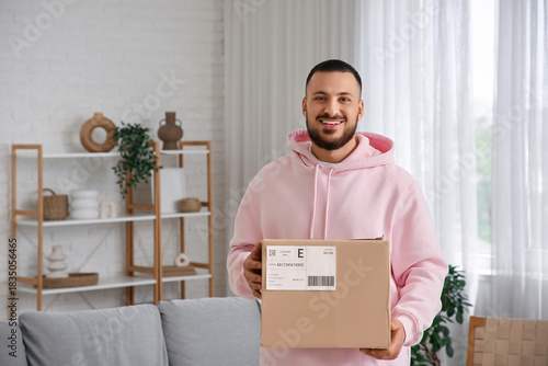 Young man with parcel at home