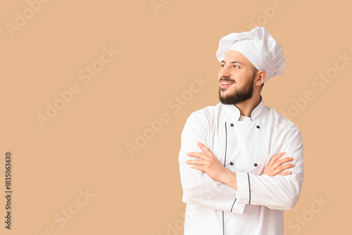 Male chef smiling on beige ...