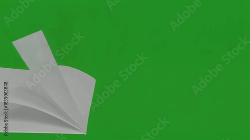 Slow motion video of a book with blank white pages turning, set against a solid green screen for easy chroma keying