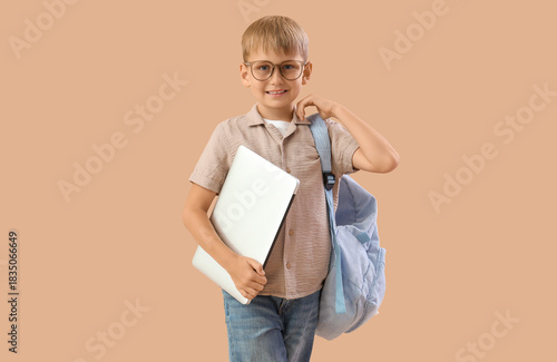 Little schoolboy with lapto...