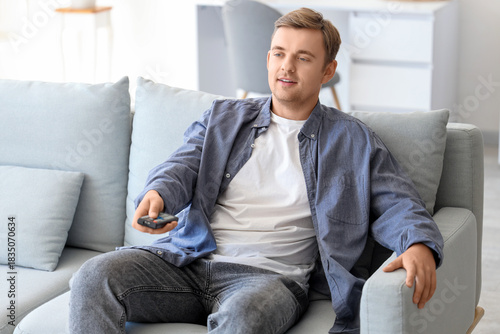 Handsome man with remote co...