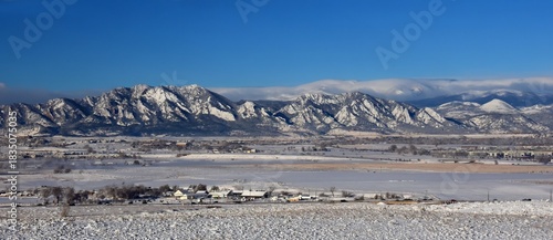the  striking boulder flatirons and  snow -capped peaks of the front range of the colorado rocky mountains in winter as seen from broomfield, colorado, in early morning