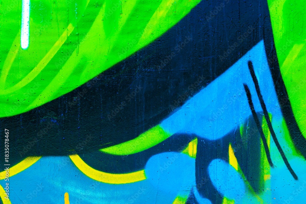 Fototapeta premium Graffiti art in neon blue, green, black, yellow. Urban 80s, Y2K aesthetic, vibrant hues, dynamic strokes. Digital art, cityscape visuals, modern 2000s creativity.