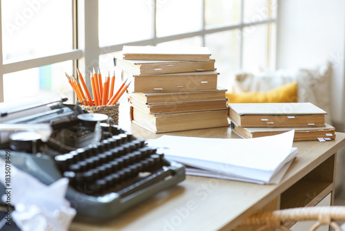 фотографія Vintage typewriter with script, books and crumpled paper on desk in screenwriter