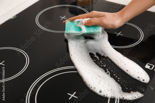 Woman cleaning black glass ...