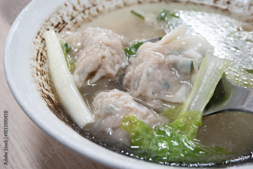 Delicious wonton soup with green vegetables.