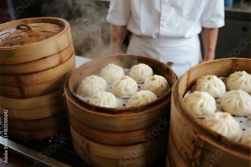 Steaming buns in bamboo baskets with chef in background