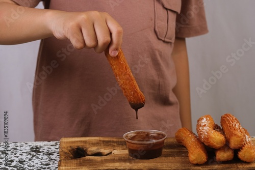 A churro dripping chocolate, creating a delicious and visually appealing food-focused closeup scene.