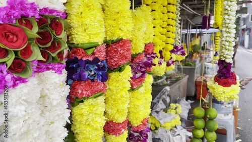 Bright flower garlands made of roses, chrysanthemums, jasmine, orchids, and limes hang at a stall in Little India, Kuala Lumpur, showcasing the vibrant colors of Indian cultural traditions