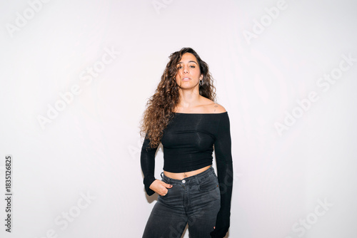 Young woman confidently posing with curly hair and black top