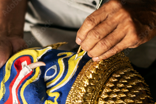 close up of artist painting lakhon khol traditional mask in cambodia