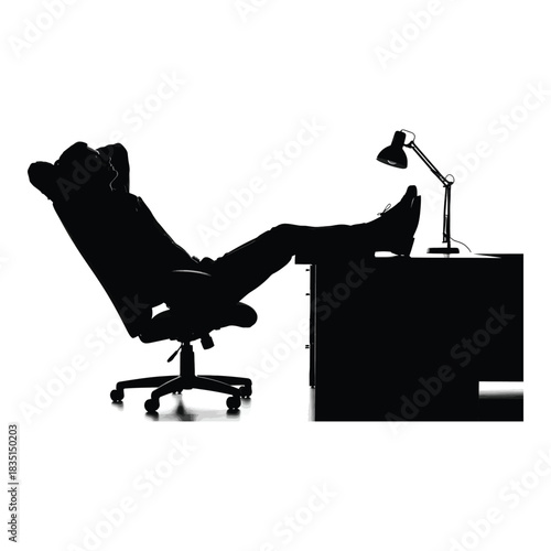 Silhouette of relaxed worker with feet on desk after hours in modern office