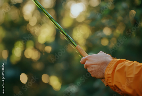 A person holding a fishing rod with a green handle