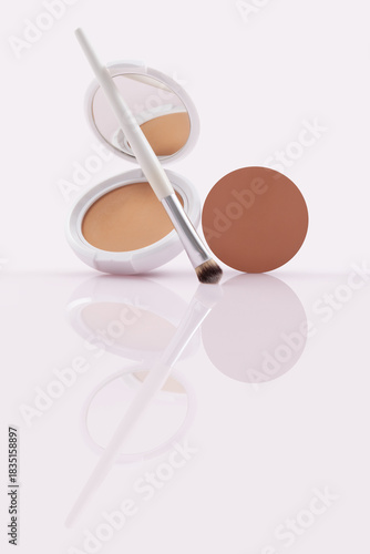 Opened compact powder, blusher with makeup Brush and  refill pan on Glossy Surface