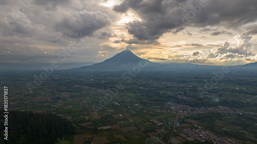 Farmland and active Sinabung volcano. Agricultural landscape in Sumatra. Berastagi, Indonesia.